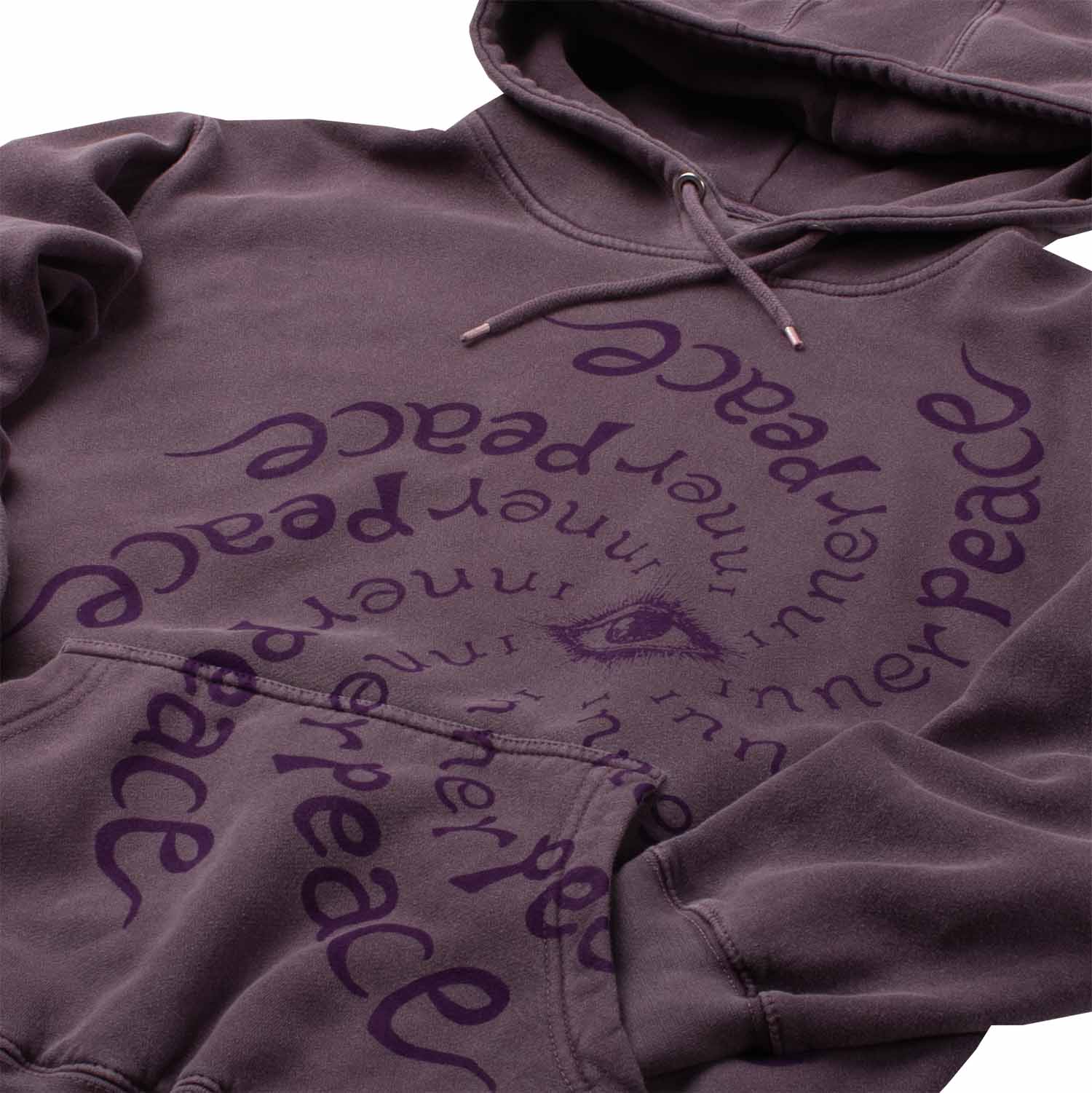 Closeup detail photo of many repetitions of "Inner Peace" text circling an "all seeing eye". Altru Inner Peace Dark Purple Hoodie. Garment dyed and washed for soft vintage look and feel,