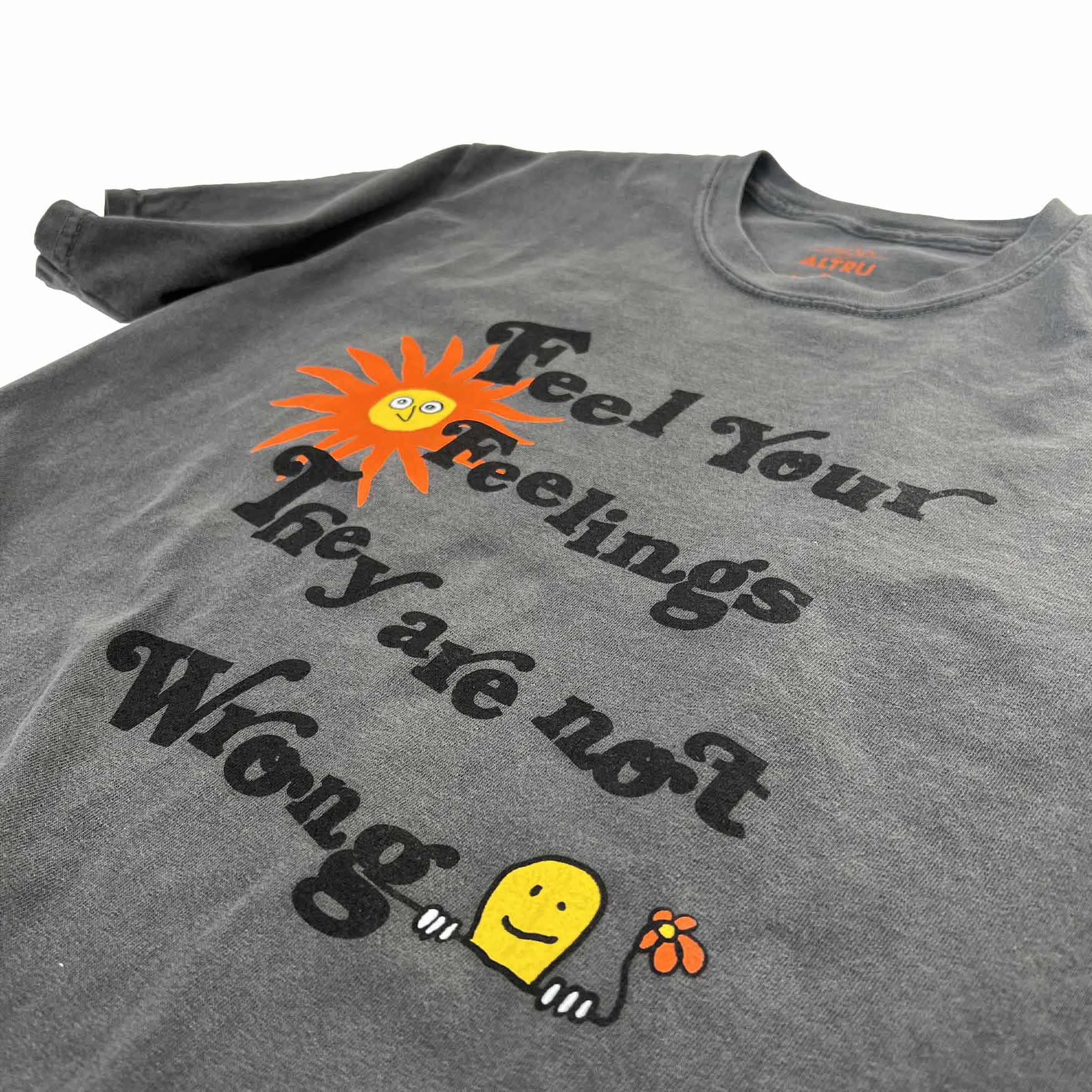 Altru "Feel your feelings they are not wrong" t-shirt. Positive text printed on pigment dye vintage black. Front image close up 2