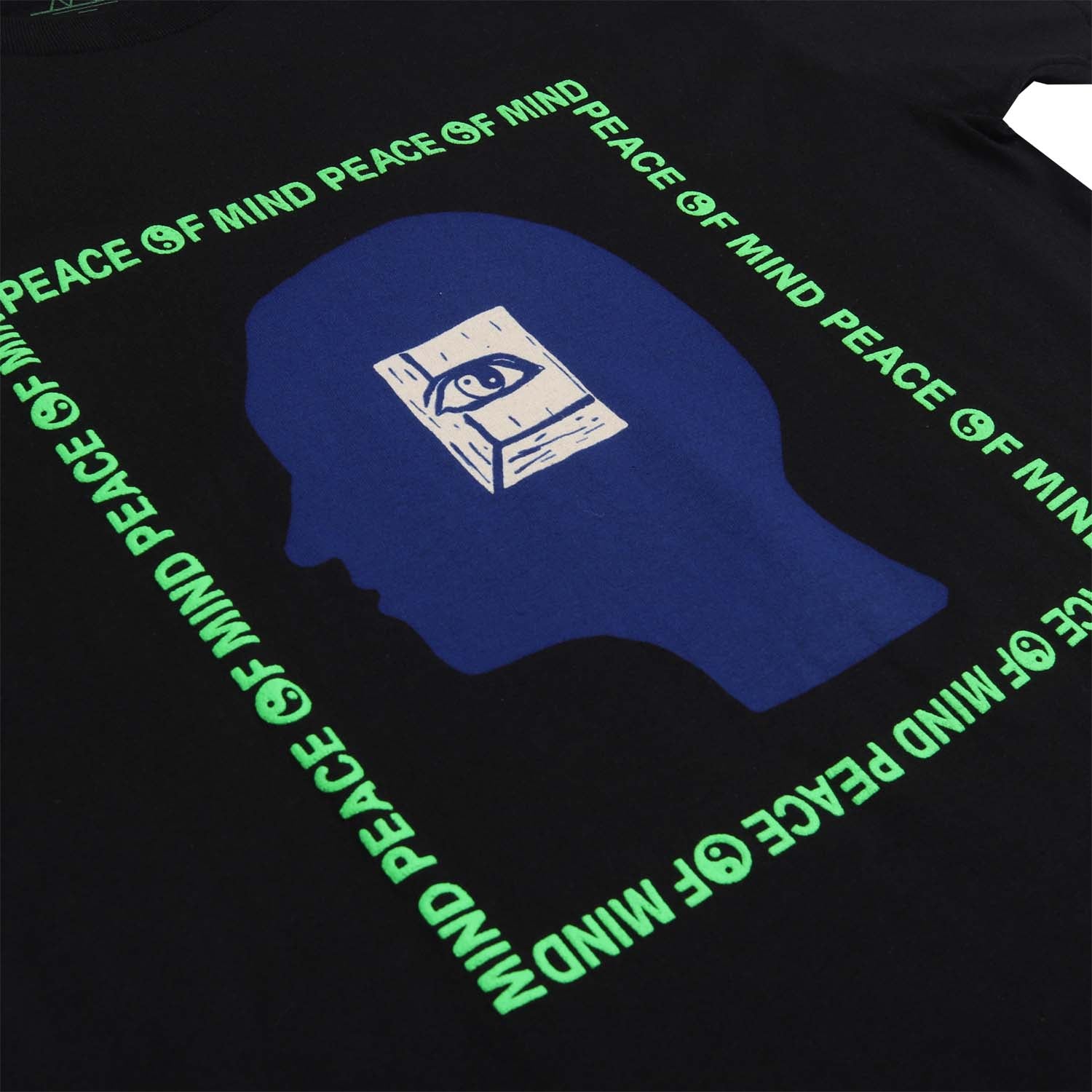 Peace of Mind text on black graphic tee. Yin Yang symbols in green puff ink. Graphic of a head with an inner eye over the head silhouette. graphic. Short sleeve black tee with green puff ink, blue head and white inner eye. 3rd front detail of tee. Altru Apparel.